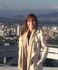 Brenda Murueta posing for a photo above a city skyline